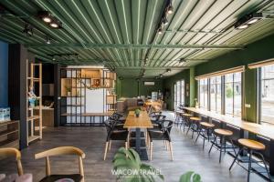 a restaurant with green ceilings and tables and chairs at Twenty Eight B&B in Xiaoliuqiu