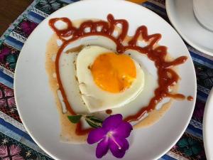 a plate with an egg in the shape of a heart at Baanmalai Hotel Chiangrai in Chiang Rai