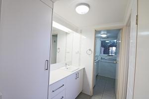 a bathroom with a sink and a mirror at Pelican Waters in Merimbula
