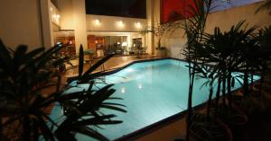 a large swimming pool in a building with plants at Convair Hotel in Ciudad del Este