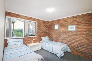 A bed or beds in a room at Pelican Waters