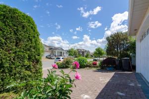 Una pasarela de ladrillo junto a una casa con un seto en 3 Private, spacious, bright rooms in a Gorgeous house, en New Westminster