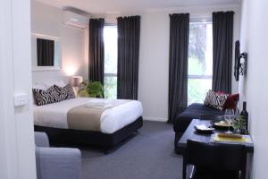 um quarto de hotel com uma cama, uma mesa e um sofá em Prom Country Lodge em Foster