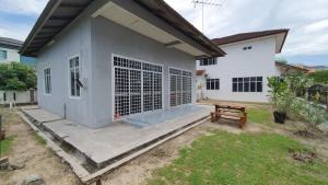 una casa con una panca di legno di fronte ad essa di 3H REST HOUSE @ HOMESTAY a Kuala Terengganu