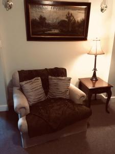 a living room with a couch and a table with a lamp at Niagara Mansion Carriage Suite in Lewiston