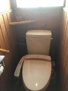 un piccolo bagno con servizi igienici e telecomando di Ryokan Fujitomita a Oshino
