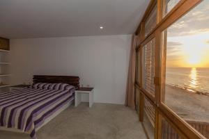 a bedroom with a bed and a view of the ocean at Canoas Lofts in Canoas De Punta Sal
