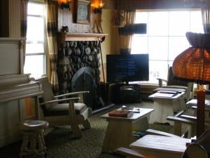 a living room with a fireplace and a television at Hotel Motel Bon Accueil in Rivière-la-Madeleine