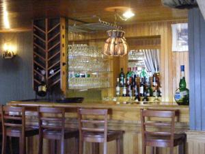 a bar with chairs and bottles of wine at Hotel Motel Bon Accueil in Rivière-la-Madeleine