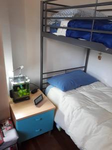 een slaapkamer met een stapelbed en een aquarium op een nachtkastje bij La Giara in La Spezia