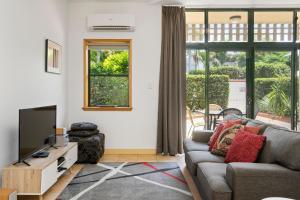 a living room with a couch and a tv at Byron Getaway @the Crest in Byron Bay