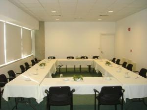 une salle de conférence avec des tables et des chaises blanches dans l'établissement Allegra GSP Sport Center, à Nicosie