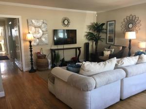 Una sala de estar con un sofá blanco y un televisor. en Incredible Los Angeles Beach Home with Amazing Ocean Views, en Los Ángeles