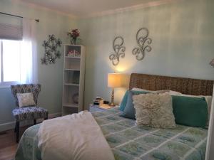 un dormitorio con una cama y una silla en Incredible Los Angeles Beach Home with Amazing Ocean Views, en Los Ángeles