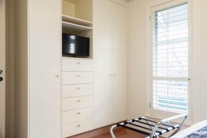 1 dormitorio con vestidor y TV en Domain One Apartment, en Mount Gambier