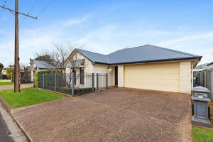 a house with a garage and a fence at Domain One Apartment in Mount Gambier