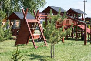 a playground with a wooden play structure in a yard at Mandarynka OW in Jarosławiec
