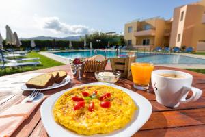 a table with a plate of food and a cup of coffee at Alonia Hotel Apartments in Kolymvari