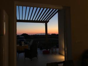 an open door to a patio with a view of the sunset at Casa Vigna da Michela in Favignana