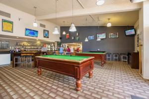 a billiard room with two pool tables and a bar at Kondari Hotel in Hervey Bay