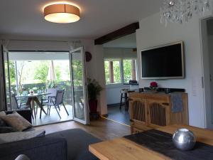 sala de estar con TV y mesa con sillas en Ferienwohnung Schwarzwald-Traum, en Haslach im Kinzigtal