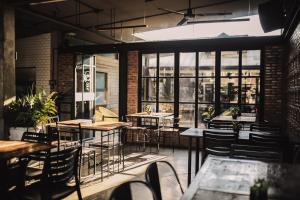 a restaurant with tables and chairs and windows at The Flying Fish Hostel in Dumaguete