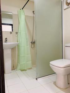 a bathroom with a shower and a toilet and a sink at Sherwood Cottage in Nuwara Eliya