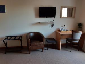een kamer met een bureau, een stoel en een televisie bij Vlei Lofts in Kaapstad