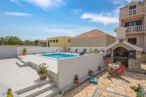 un cortile con piscina e una casa di Villa Sunshine a Rogoznica (Rogosnizza)