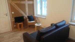a living room with a couch and a tv at Mirabellenhof - Kleine Ferienwohnung mit Altstadtblick in Biesenthal