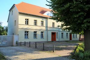 a large white building with an orange roof at Mirabellenhof - Kleine Ferienwohnung mit Altstadtblick in Biesenthal