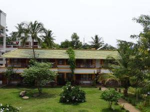 a building with a garden in front of it at Nalla Eco Beach Resort in Pondicherry