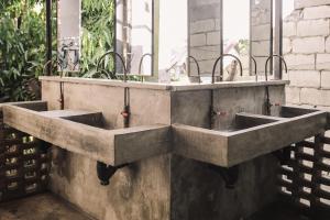 a concrete sink with a cat sitting inside of it at The Flying Fish Hostel in Dumaguete