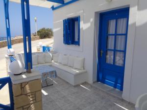 a living room with a blue door and a couch at Blue and White Studios & Apartments in Lefkos Karpathou