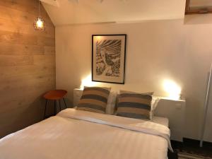 a bedroom with a bed with two pillows and a picture on the wall at Poortbossen in Zottegem