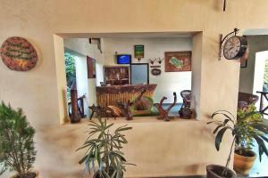 a room with potted plants and a room with a counter at Serenity Corbett Resort in Garjia