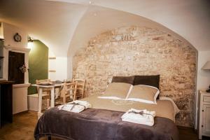 a bedroom with a large bed and a stone wall at HOME 5 - Via Nuova in Putignano