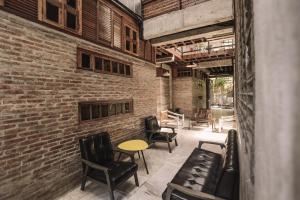 a room with chairs and tables and a brick wall at The Flying Fish Hostel in Dumaguete