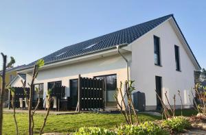 a white house with a solar roof at Ferienhaus Traumspot in Wiek auf Rügen 