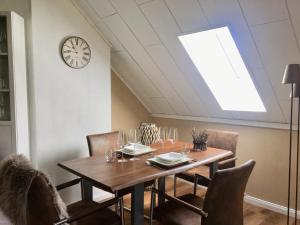 a dining room table with chairs and a clock on the wall at Luxuriöse 3-Zi. Ferienwohnung Jagdromantik 200 m bis zur Wurmbergsseilbahn in Braunlage