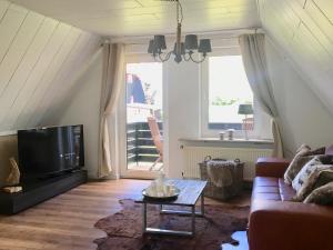 ein Wohnzimmer mit einem Sofa und einem TV in der Unterkunft Luxuriöse 3-Zi. Ferienwohnung Jagdromantik 200 m bis zur Wurmbergsseilbahn in Braunlage