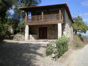 a small stone house with a balcony on top of it at Quinta de S.Vicente in Geraz do Minho +55 photos