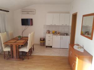 uma cozinha e sala de jantar com uma mesa de madeira em Apartments Ivanka em Sućuraj