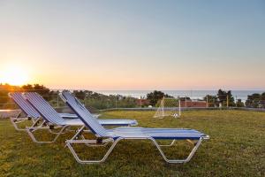 two lounge chairs sitting on the grass with a goal at Villa Rossa in Hanioti +49 photos