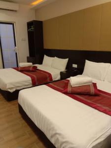 - un groupe de 3 lits dans une chambre d'hôtel dans l'établissement D'Spark Hotel Bayu, à Klang