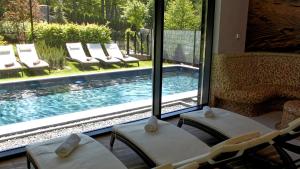 una habitación con sillas y una piscina con ventana en Hotel Sopot, en Sopot