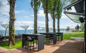 a patio with black tables and chairs and the ocean at Steigenberger Inselhotel in Konstanz +57 photos