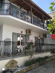un edificio blanco con un balcón con flores. en Pension Nikolas, en Skiathos