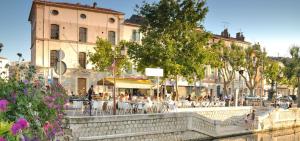 Un groupe de personnes assises à des tables dans une ville dans l'établissement Le Petit Martégal appartement spacieux en Centre ville et proche de la plage, à Martigues