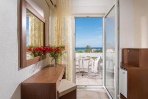 a bathroom with a window overlooking the ocean at Hotel Stefani in Sarti